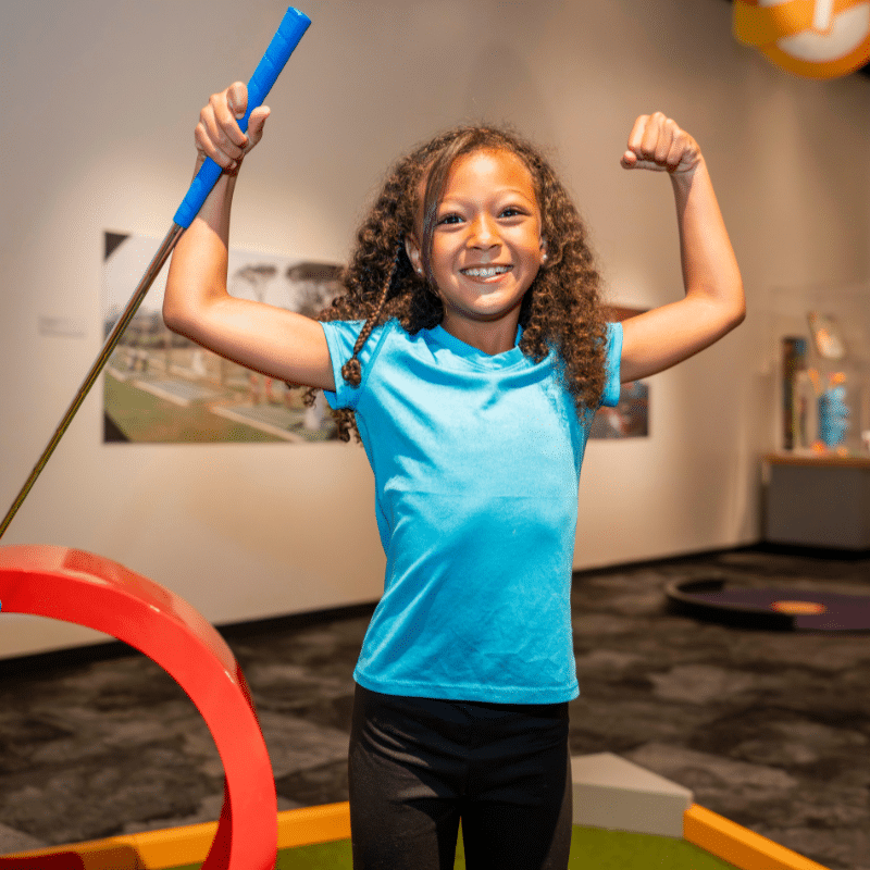 Girl Flexing with a putter in her hand